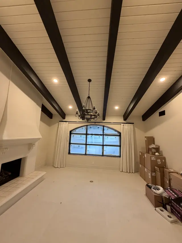 Great room with dark beams, recessed lights and a chandelier
